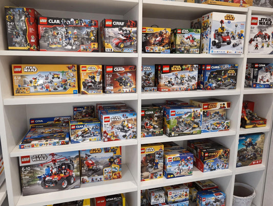 LEGO-Sets ordentlich in Regalen gelagert, mit Originalverpackungen und aufgebauten Modellen. Saubere und gut organisierte Präsentation für Sammler.